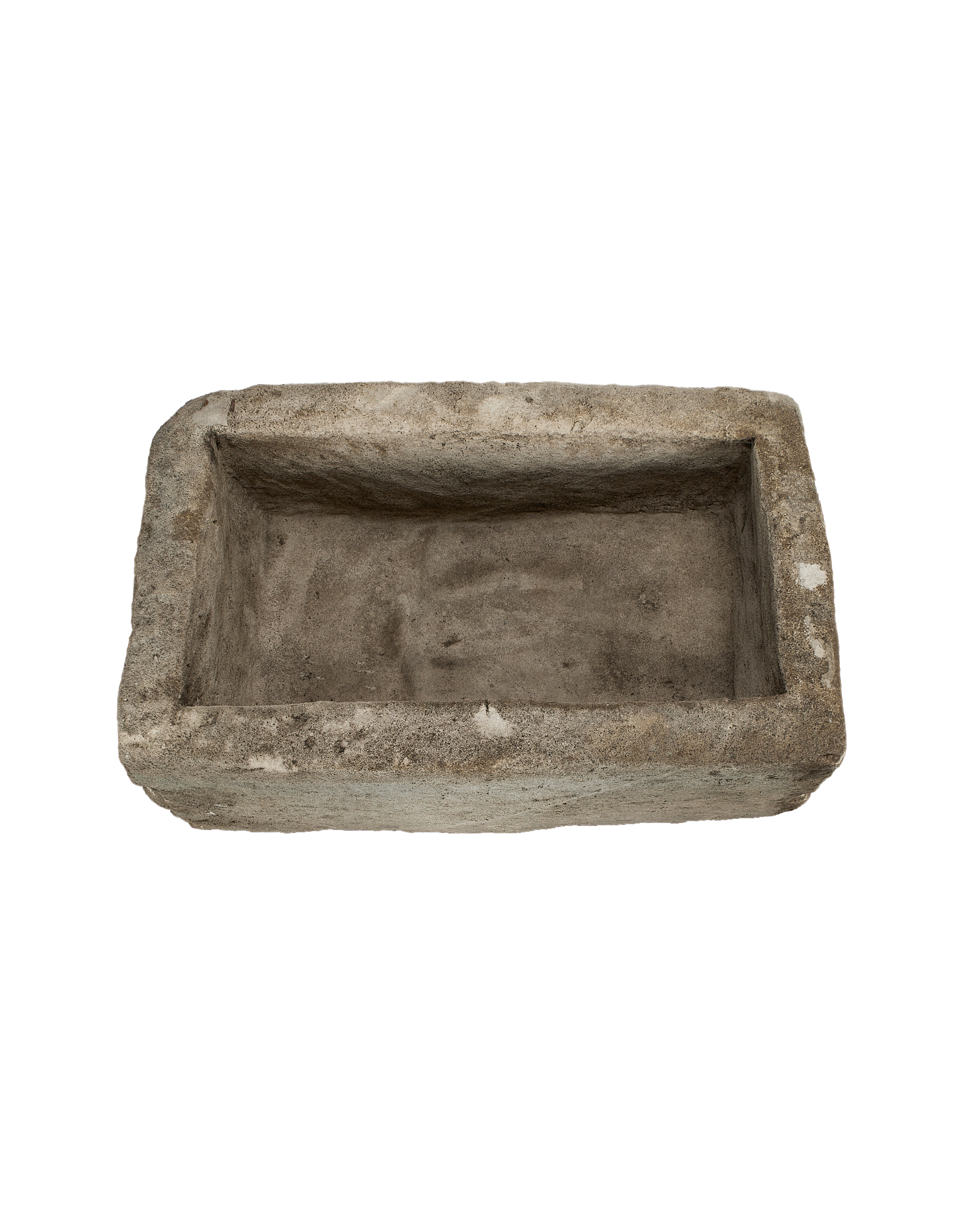 Close-up top-down view of vintage rectangular Indonesian limestone trough interior and weathered edges.