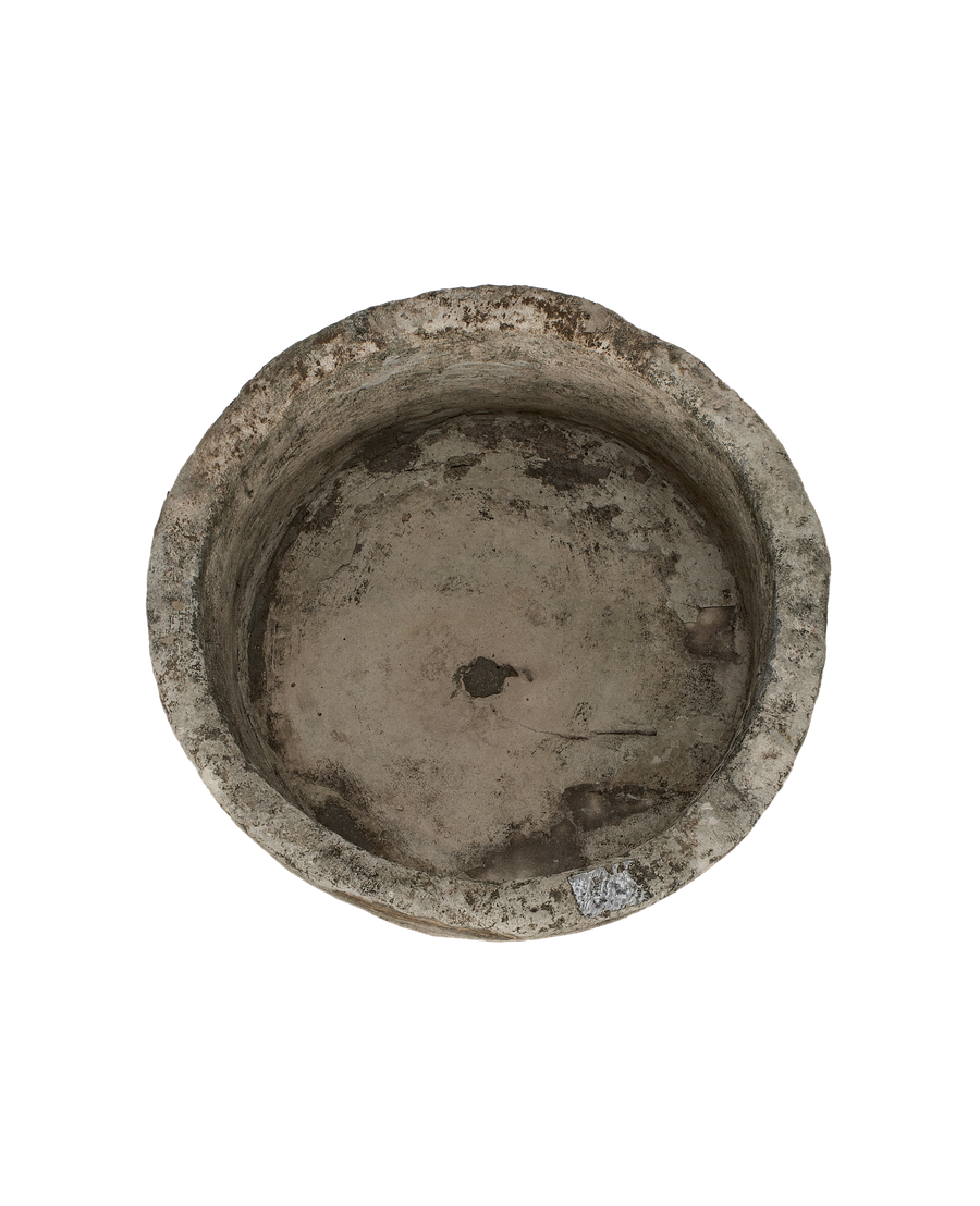 Vintage Indonesian round limestone trough, showing weathered interior with natural pit.