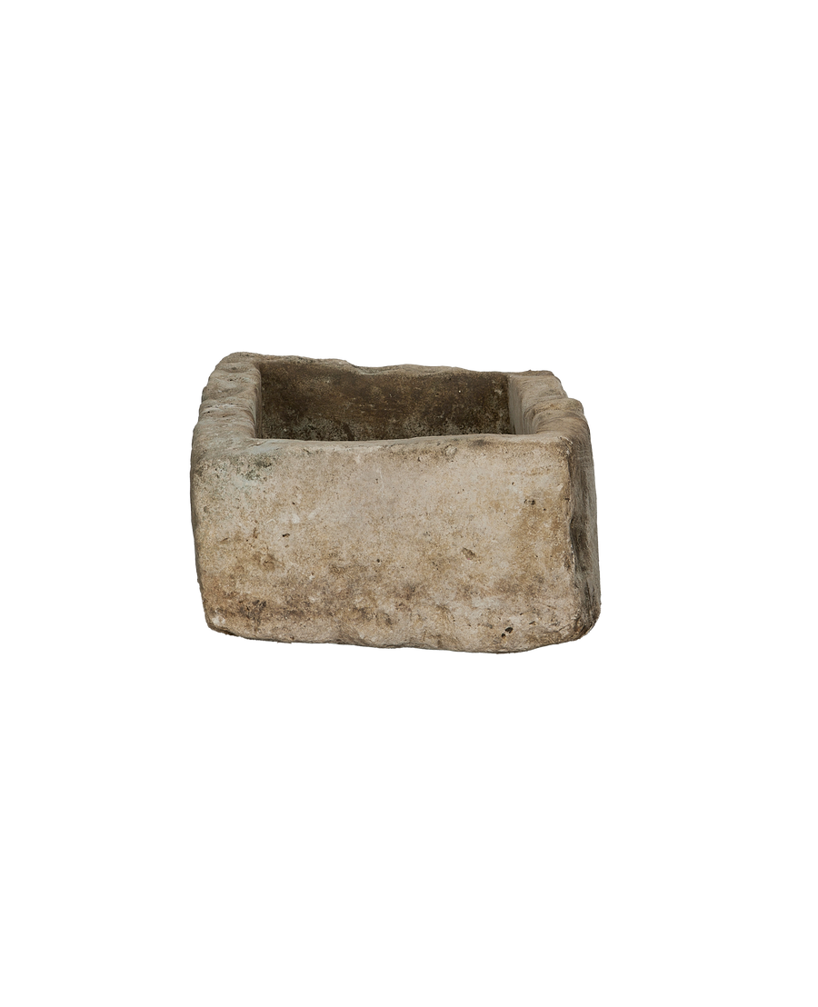 Vintage Indonesian limestone trough viewed from inside, showing rough textured interior and weathered edges.