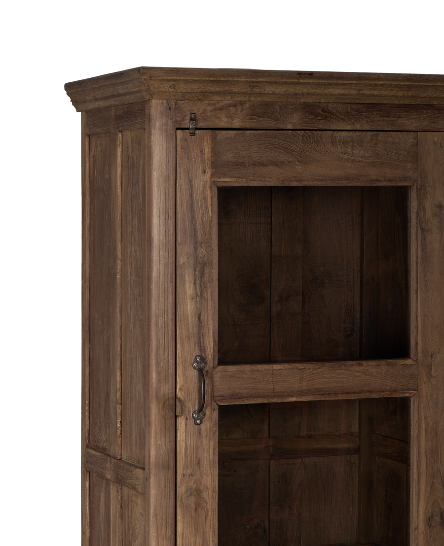 Close-up of vintage Indian oak cabinet door with distressed wood grain, glass, and antique metal handle.