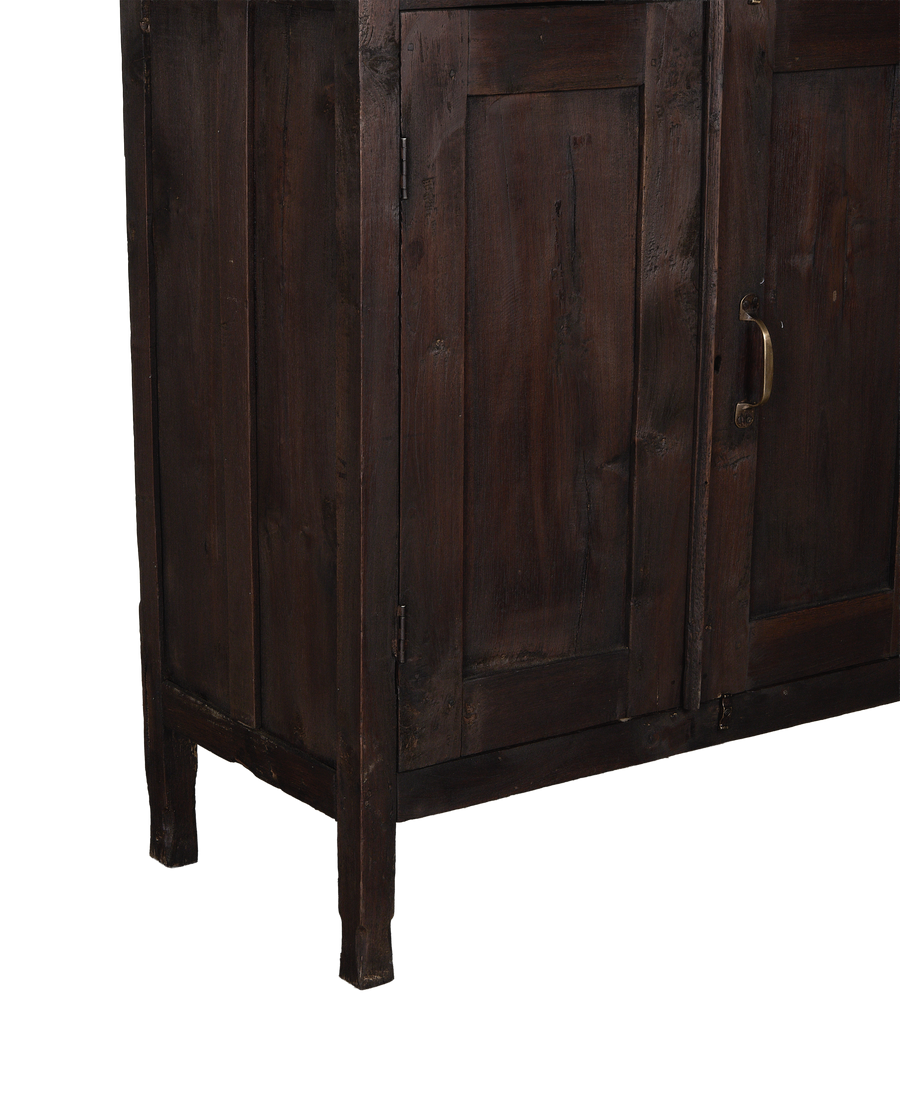 Close-up of vintage Indian oak wood cabinet's stained dark finish and brass handle.