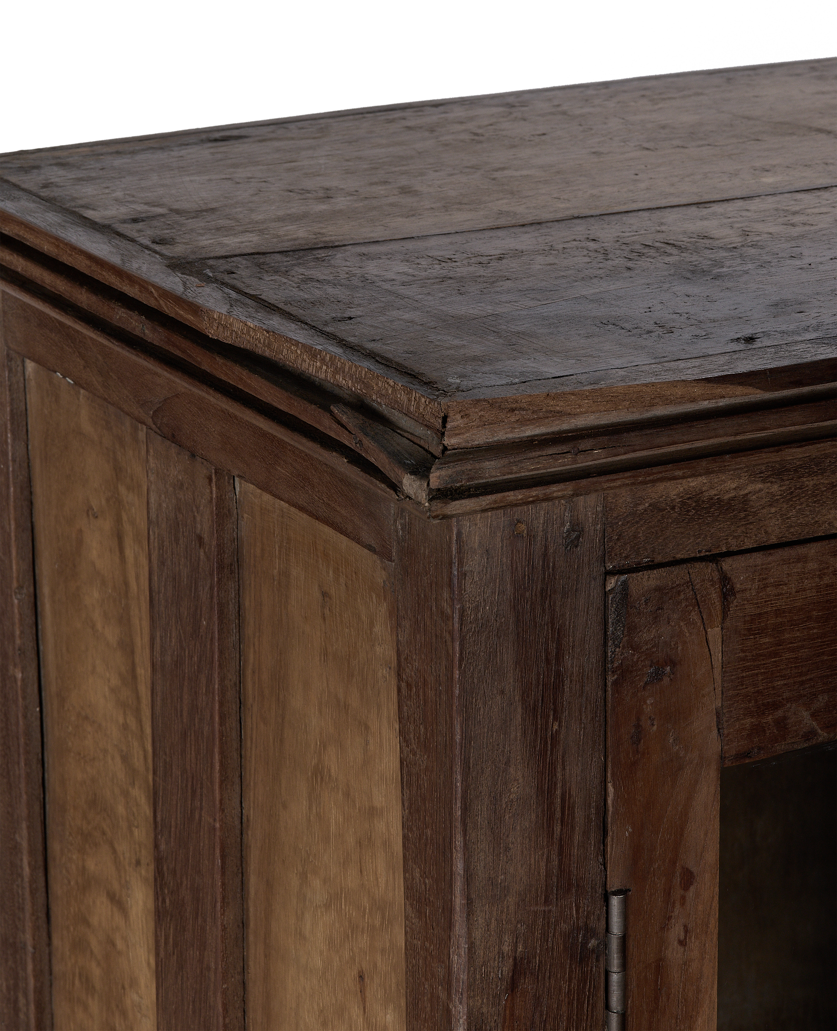 Close-up of vintage Indian oak wood cabinet corner with natural patina and detail.
