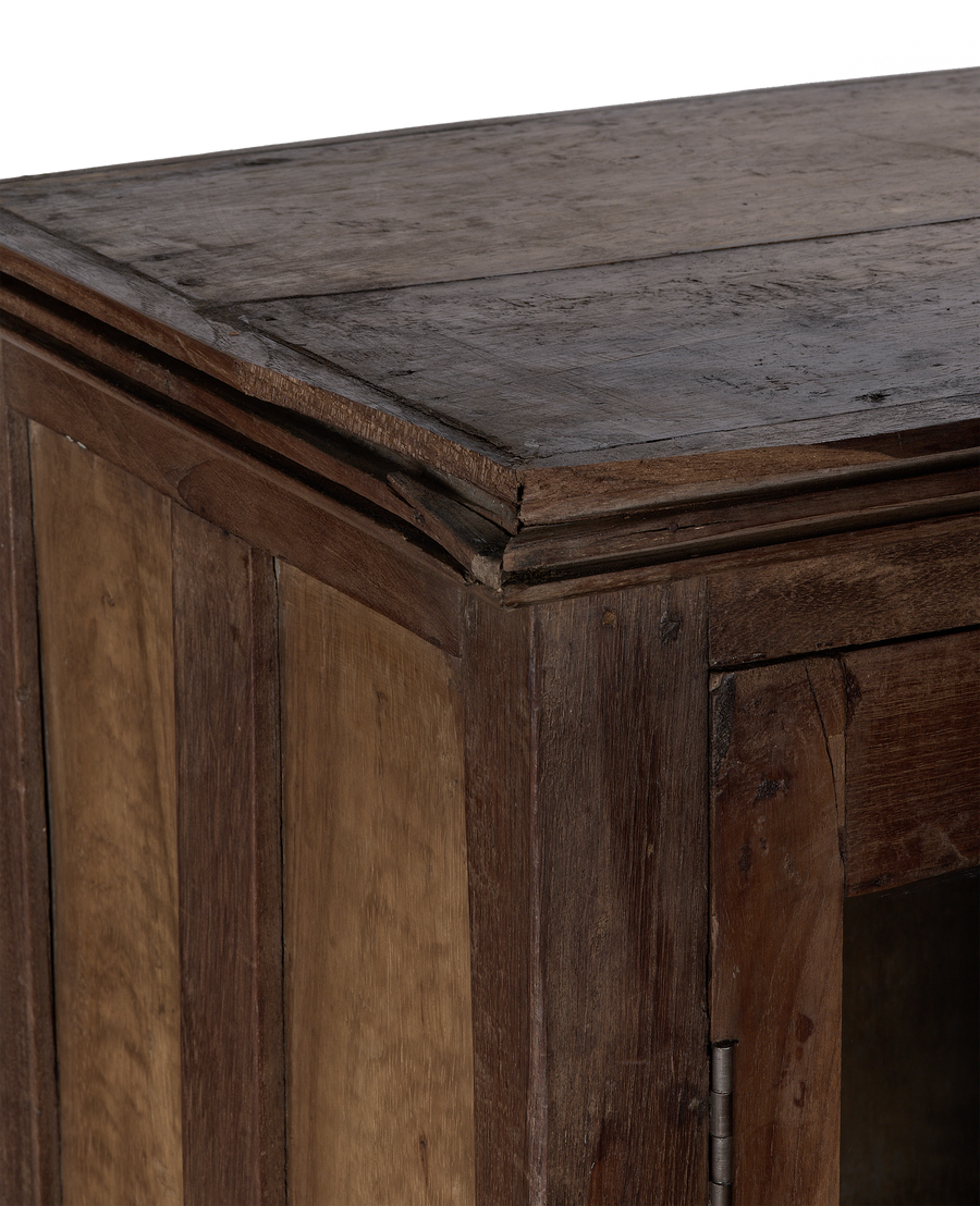 Close-up of vintage Indian oak wood cabinet corner with natural patina and detail.