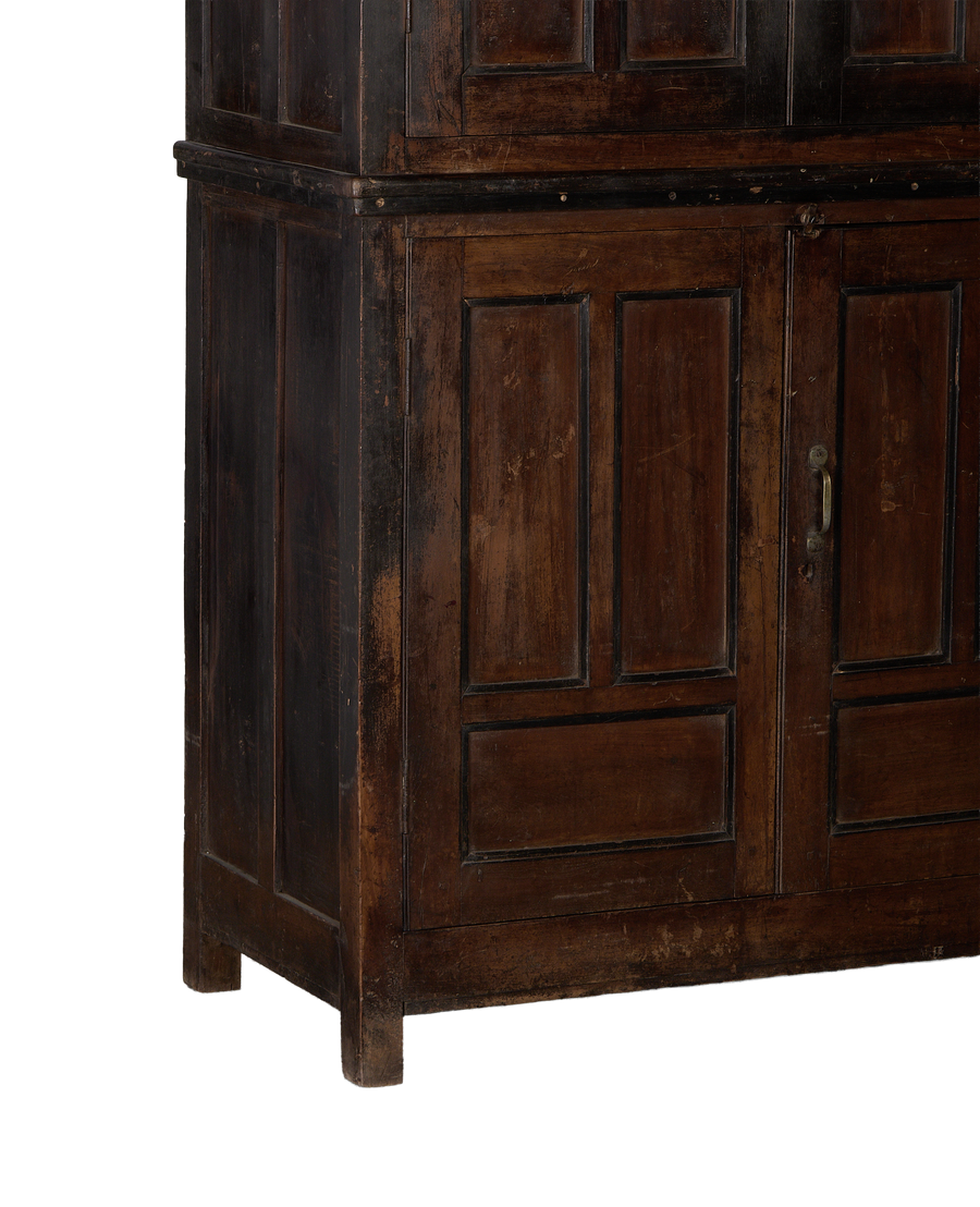 Lower section of vintage Indian oak wood cabinet, showing distressed stained finish and aged metal pull on double doors.