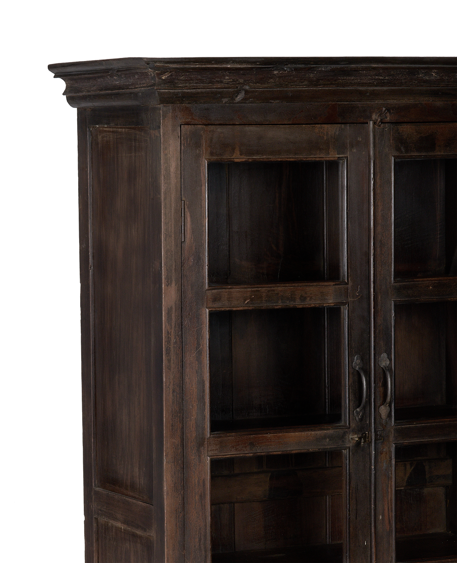 Close-up of vintage Indian oak wood cabinet's ornate crown molding and naturally distressed finish.