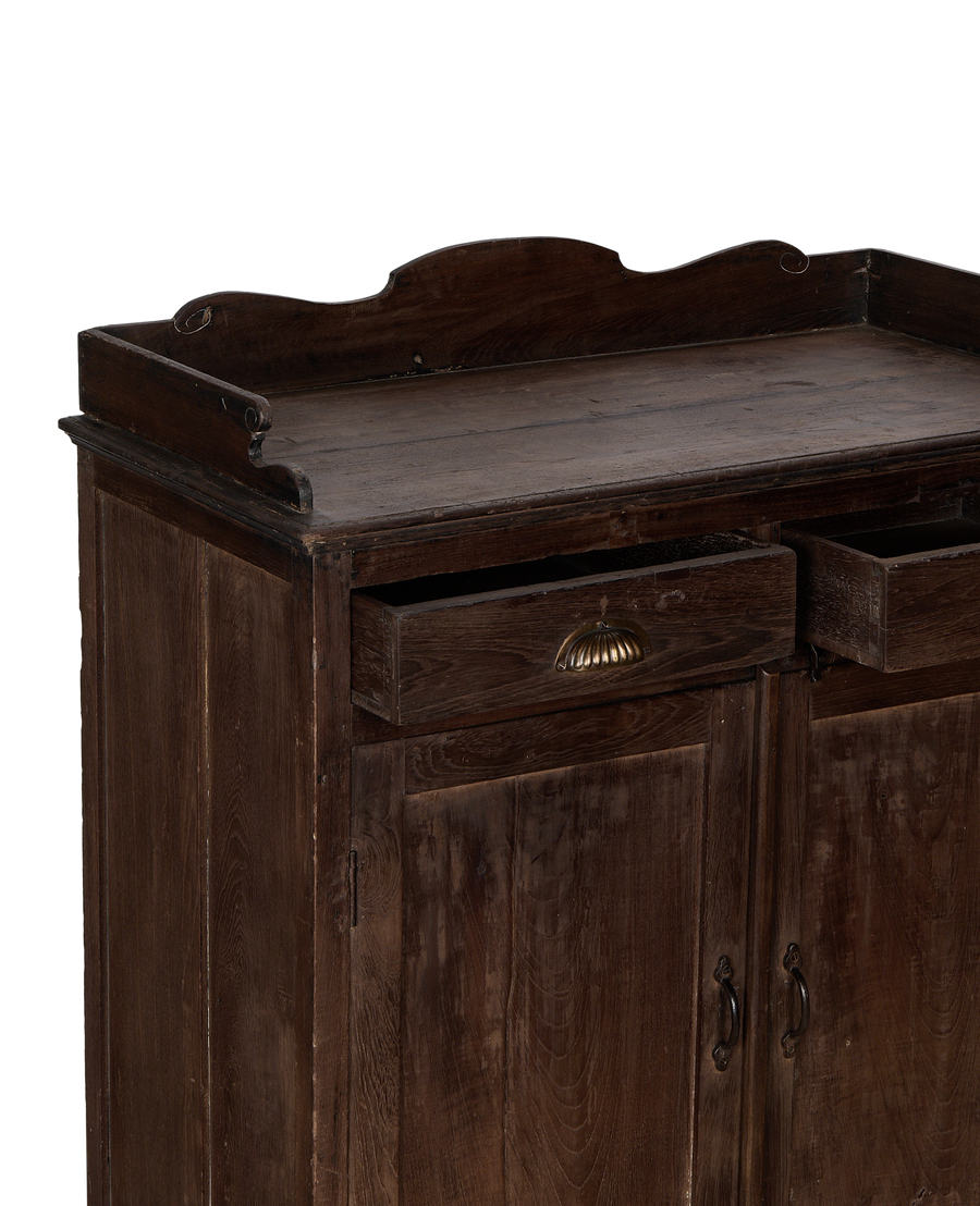 Vintage Indian oak cabinet showing partially open drawers with brass pulls, and doors below.