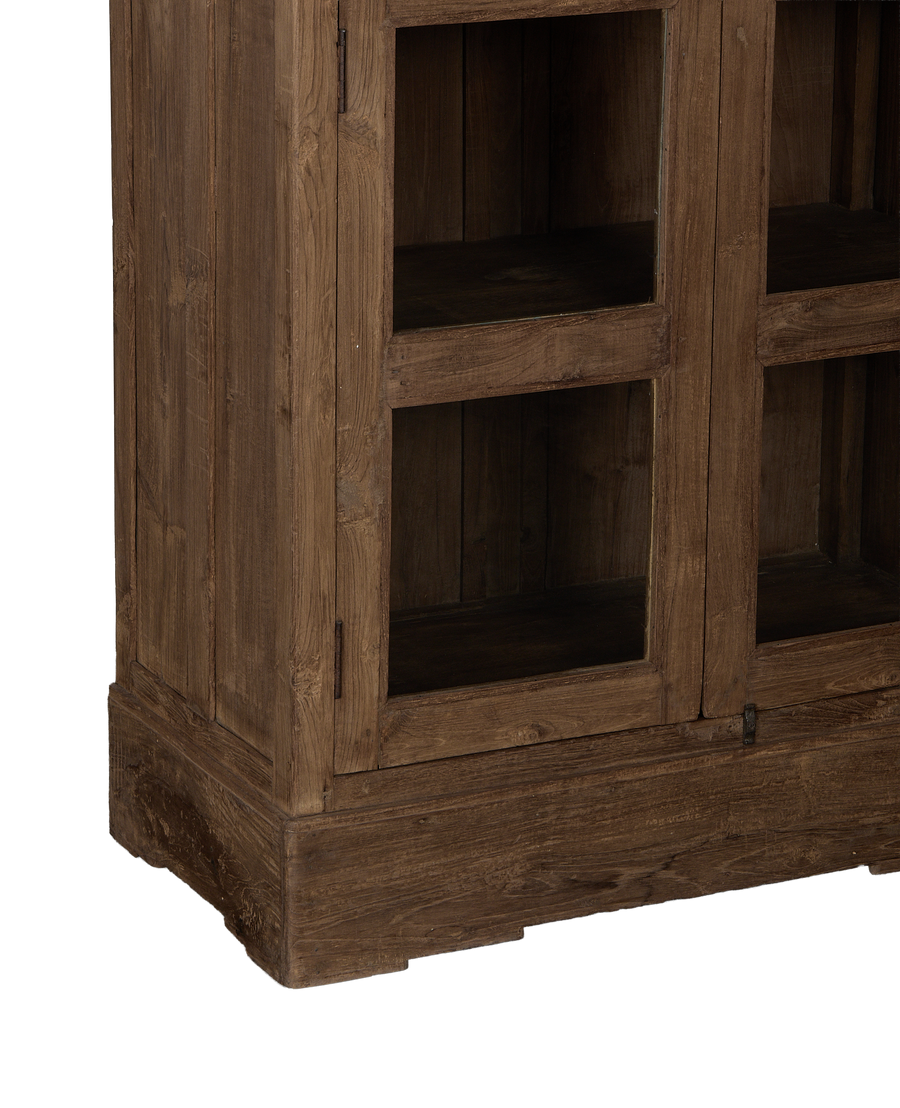 Vintage Indian oak cabinet closeup, revealing natural wood grain, textured base, and detailed glass door frame.
