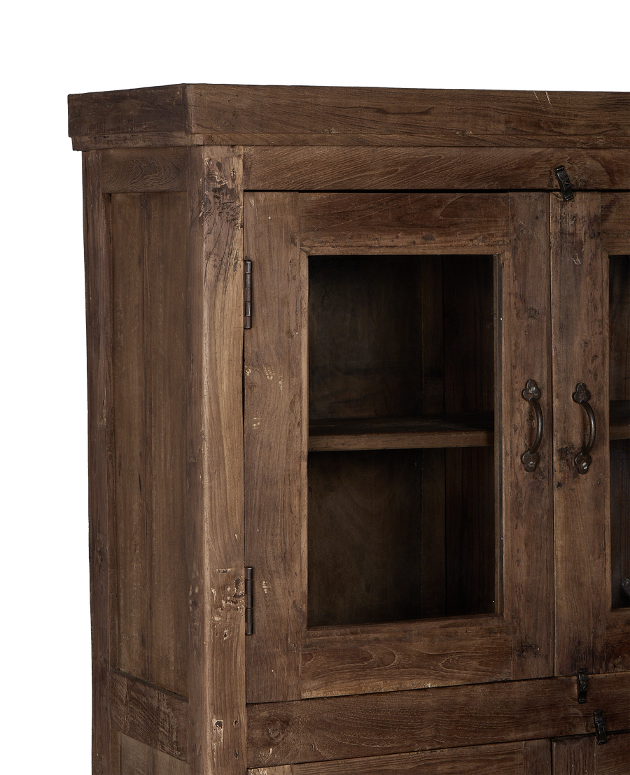 Close-up of vintage Indian oak wood cabinet's glass door, hinges, and pull handle.