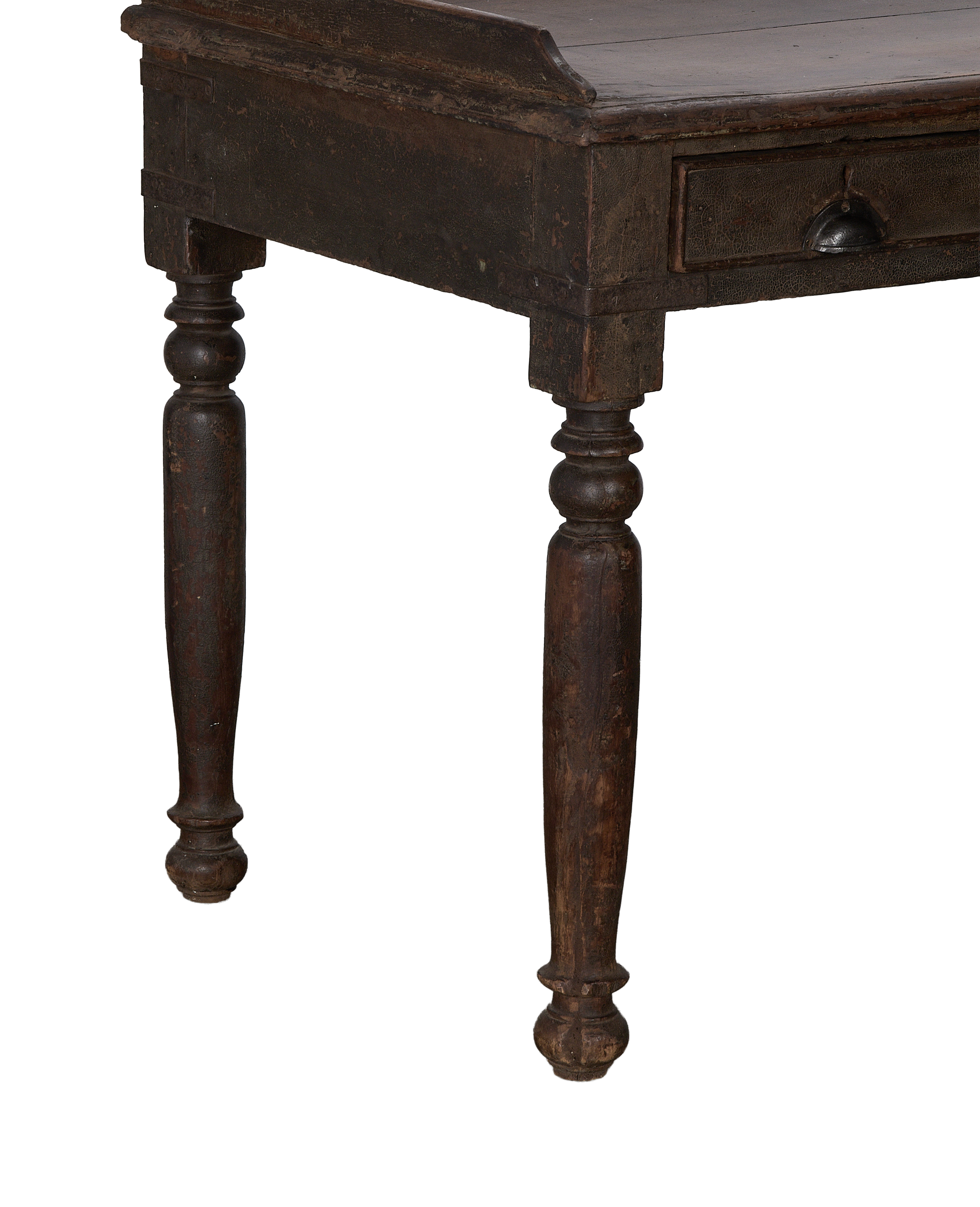 Close-up of vintage Indian oak desk with turned legs and dark, distressed finish.