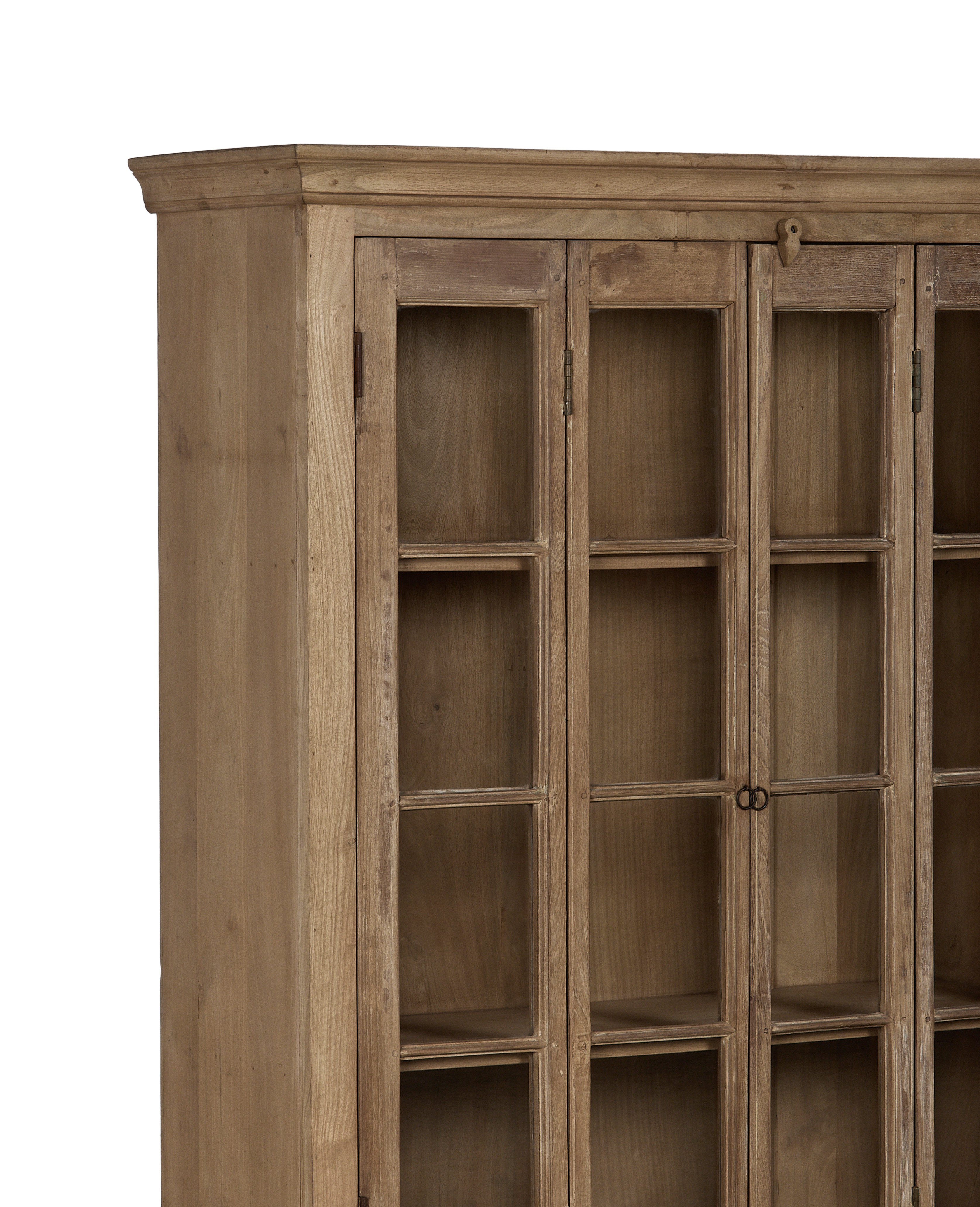 Corner detail of vintage bleached oak wood cabinet with glass doors and simple hardware.