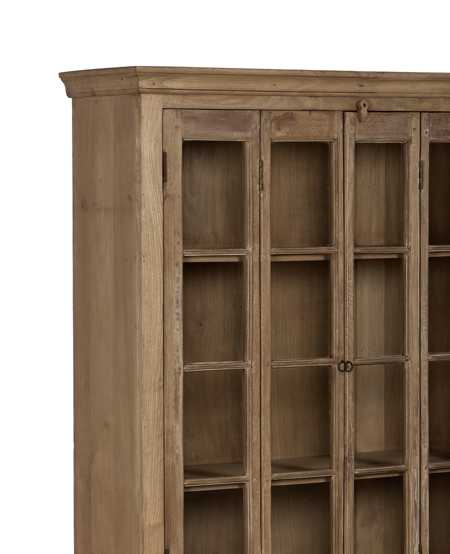 Corner detail of vintage bleached oak wood cabinet with glass doors and simple hardware.