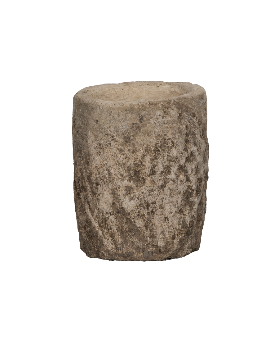 Vintage round limestone trough from Indonesia with rugged textured surface on black background.