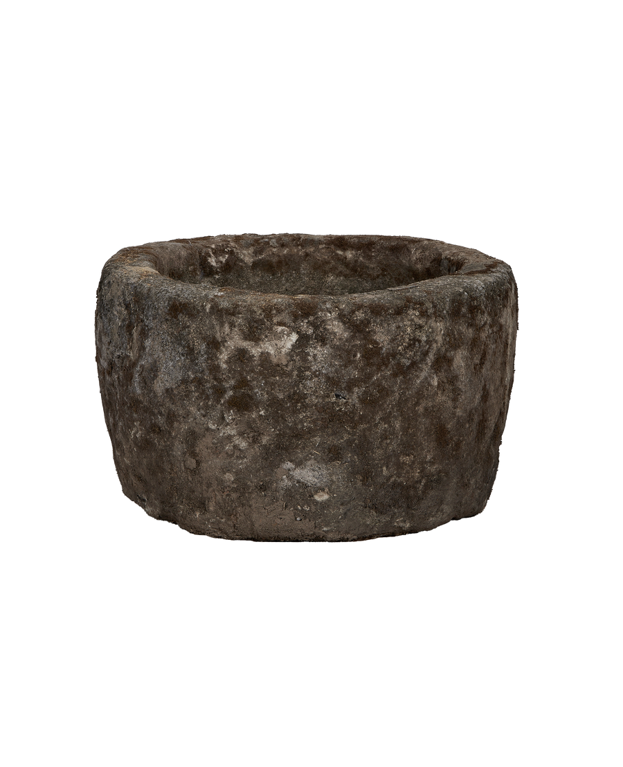 Vintage round limestone trough, rich textured surface showing wear, darker side view.