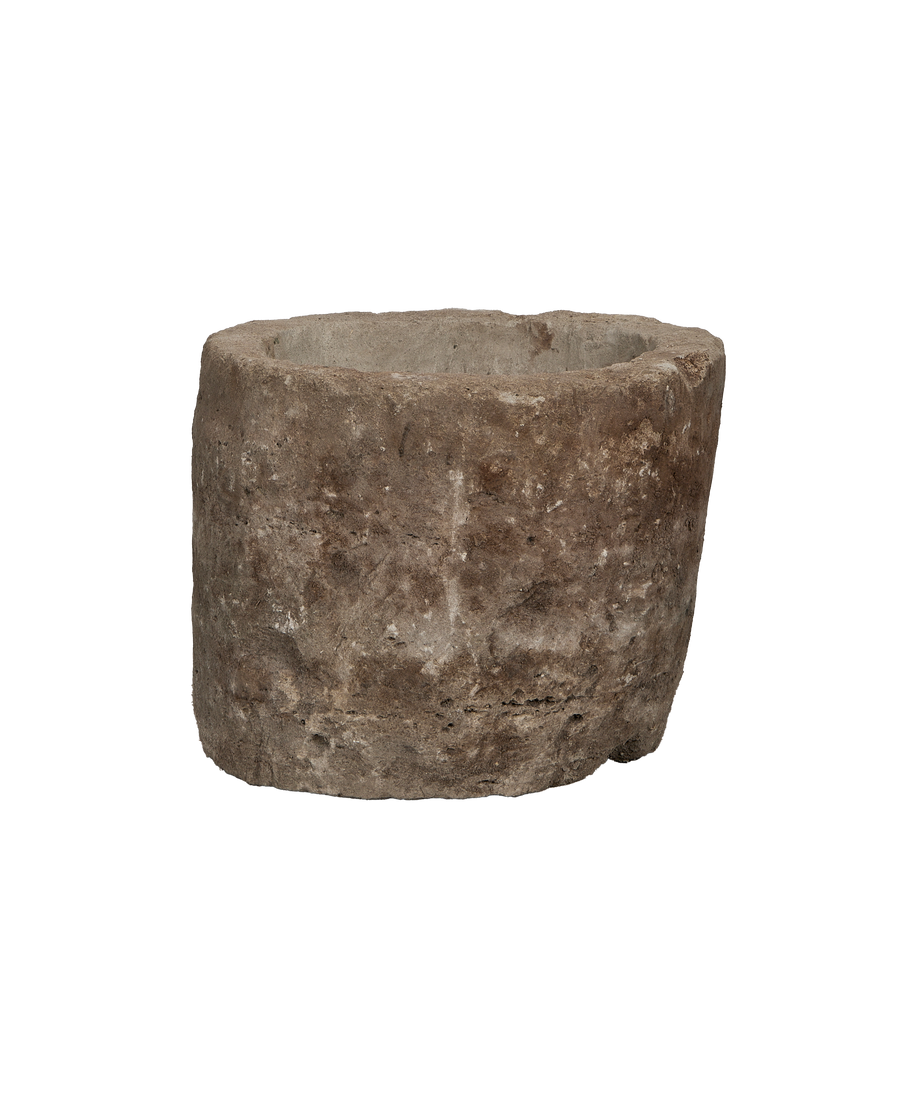 Vintage Indonesian round limestone trough, showing rugged texture and weathered gray surface.