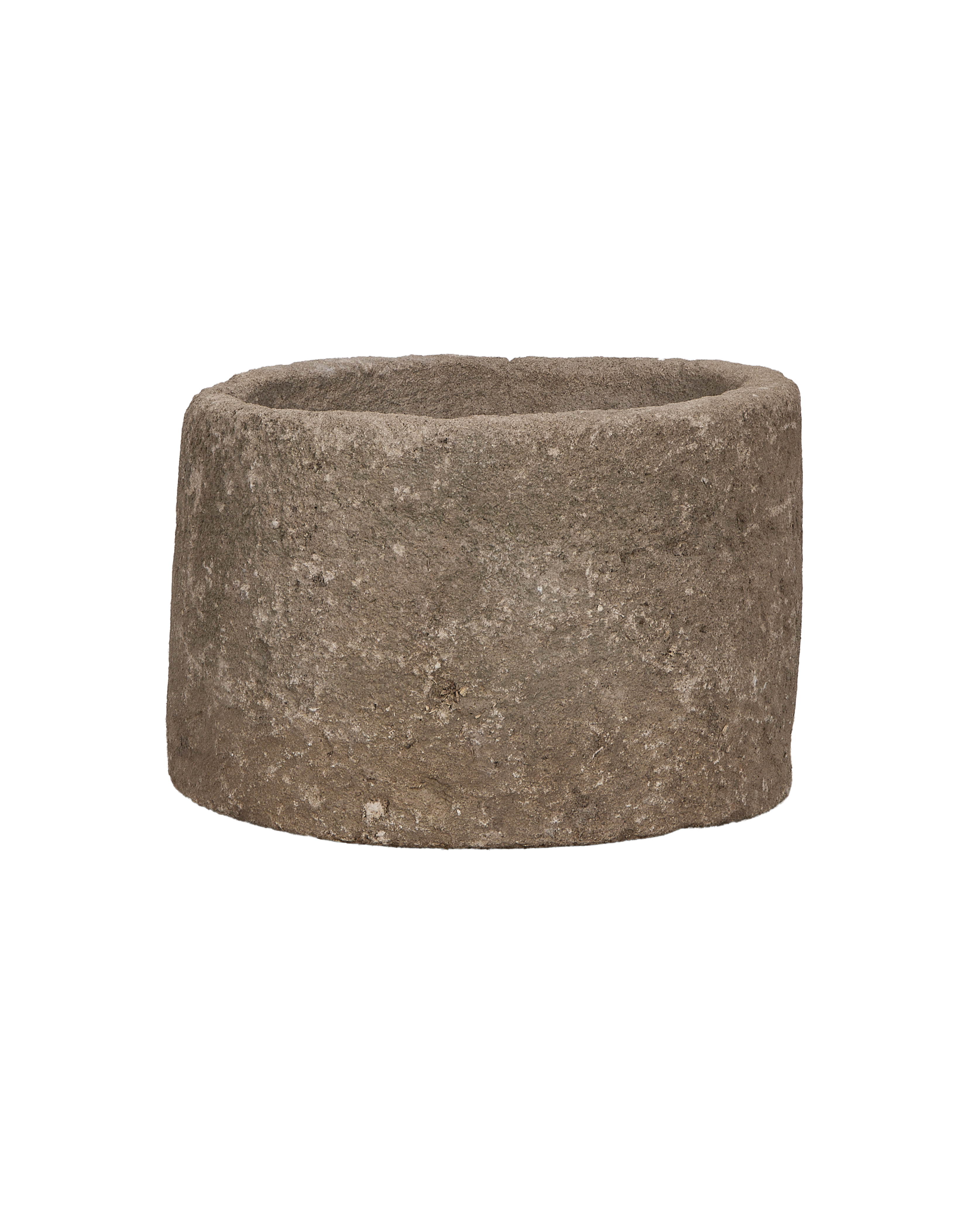 Vintage Indonesian round limestone trough, close-up texture detail from a low angle.