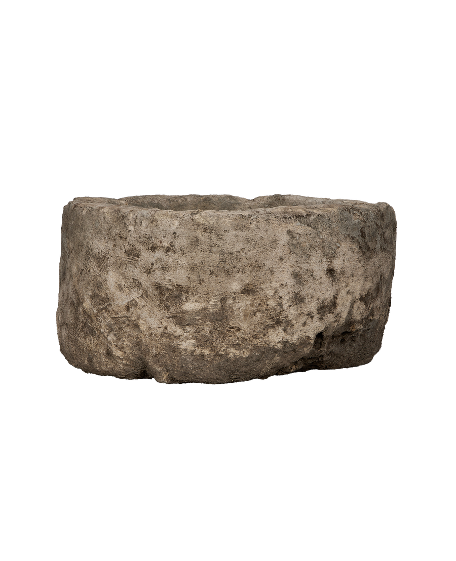 Vintage Indonesian round limestone trough, close-up of rough, weathered texture and organic shape.