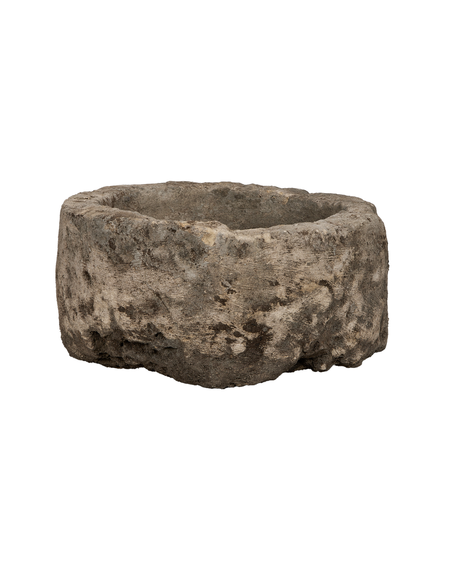 Vintage round Indonesian limestone trough, showing a side view of its rustic, weathered texture.