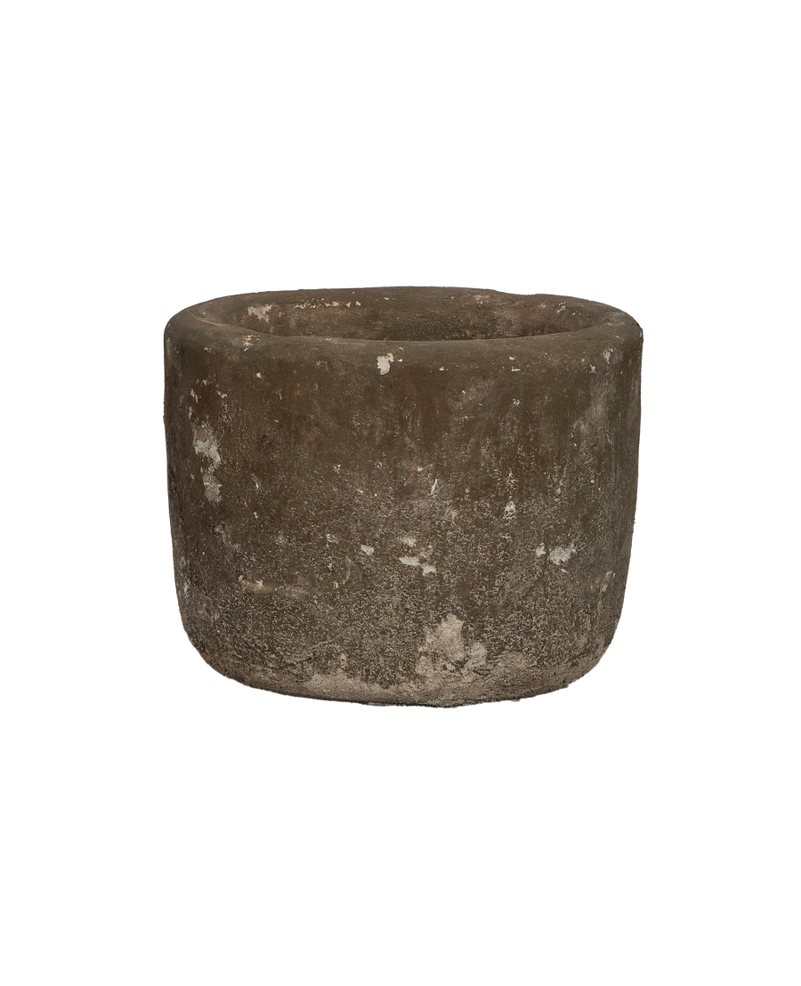 Vintage round Indonesian limestone trough, showing weathered texture from a slightly elevated side view.