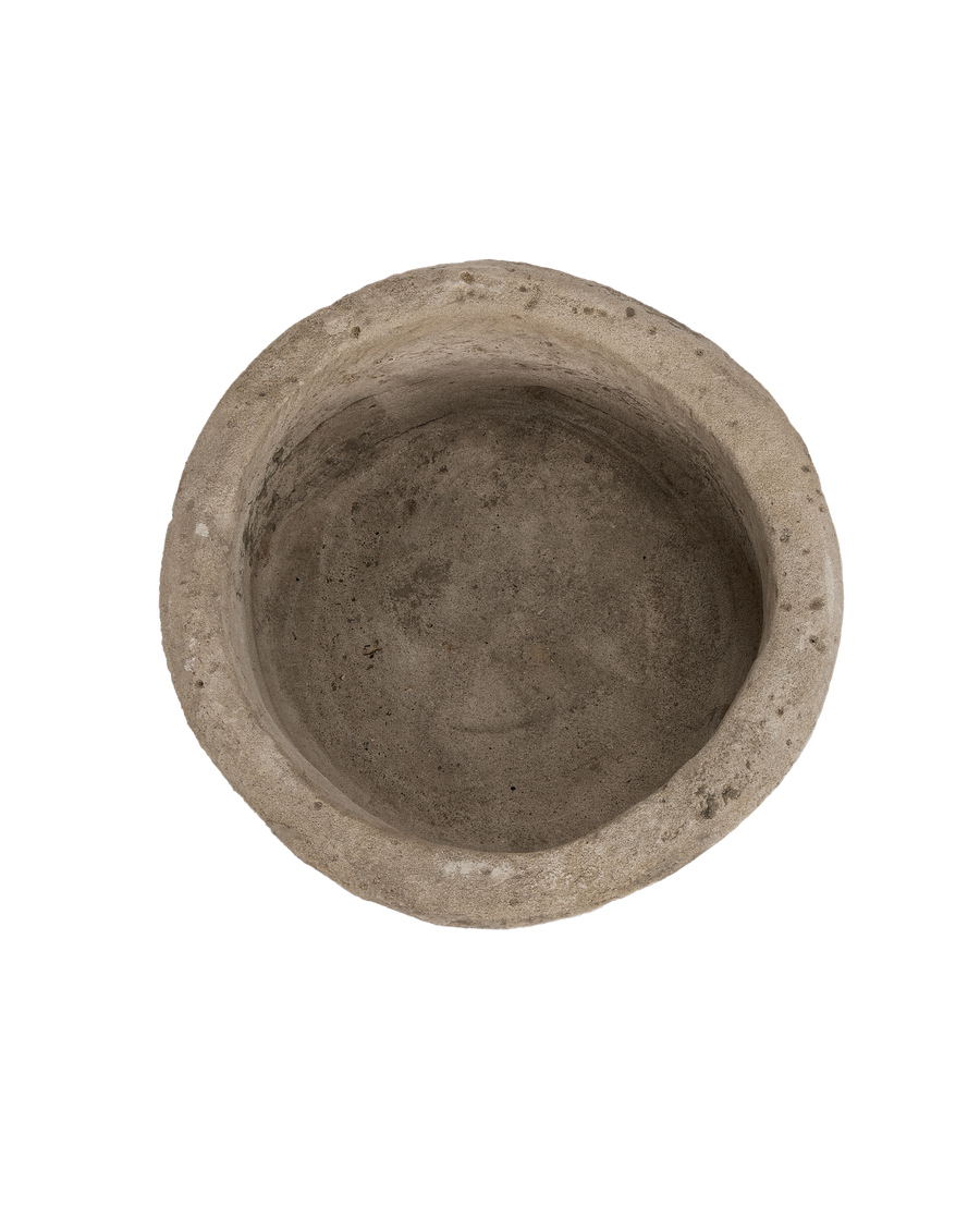 Top-down view of the vintage Indonesian round limestone trough's aged interior.