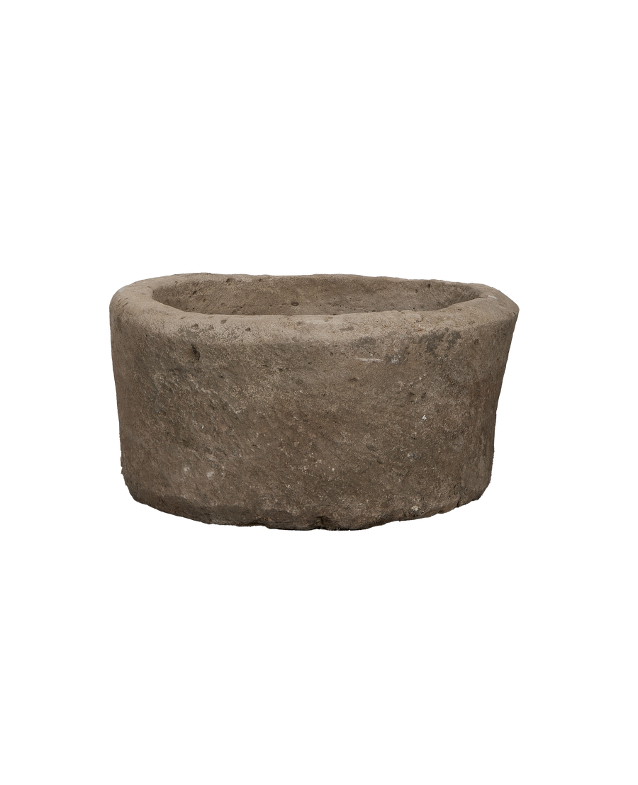 Vintage limestone round trough from Indonesia with textured, weathered natural stone surface.