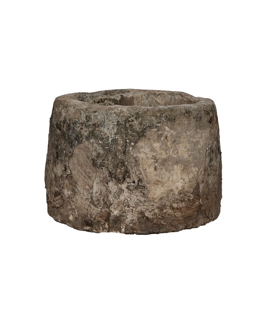 Vintage Indonesian limestone trough, round, showcasing rough, weathered texture from a lower angle.