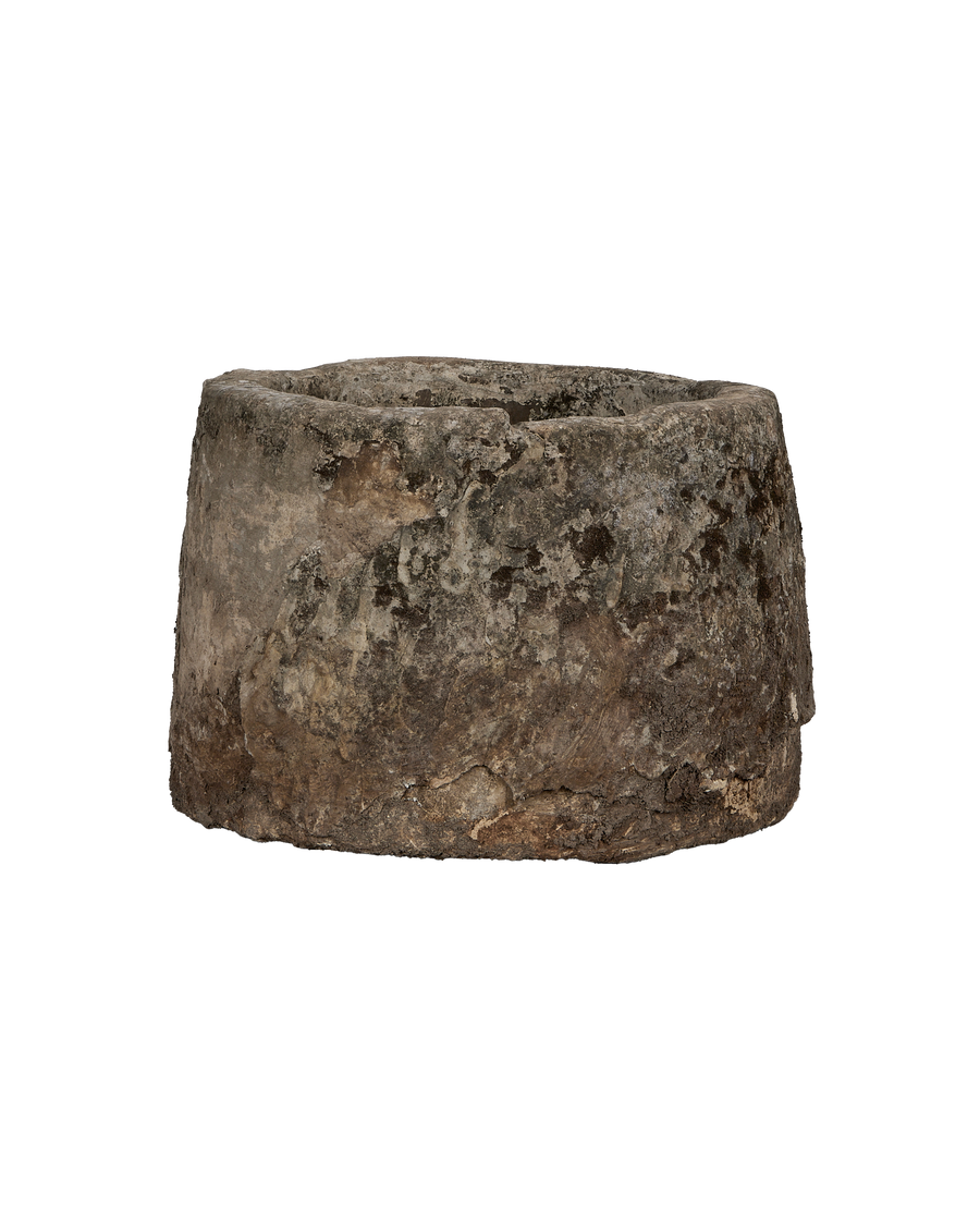 Vintage Indonesian limestone trough, round, showing detailed weathered surface texture, side view.