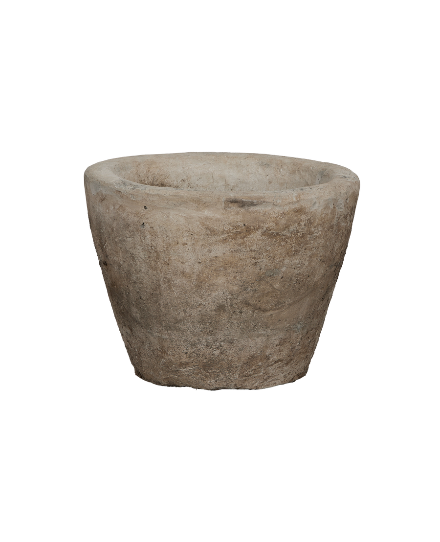 Vintage Indonesian limestone garden trough from a slightly elevated side view, showcasing its conical shape.
