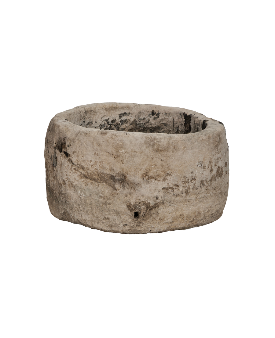 Vintage Indonesian round limestone trough, showing weathered texture and small drainage hole.