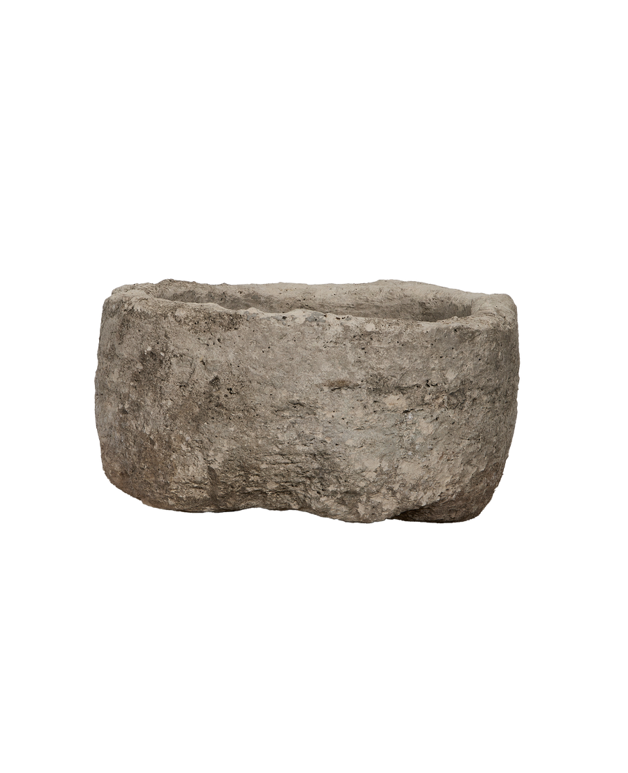 Vintage round limestone trough, side profile showcasing rough texture and natural patinas.