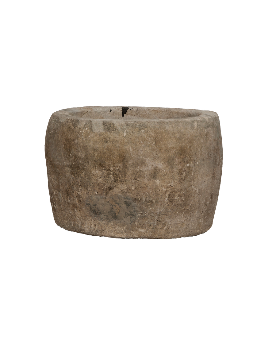 Vintage Indonesian round limestone trough, showing weathered texture and small rim imperfections on black.