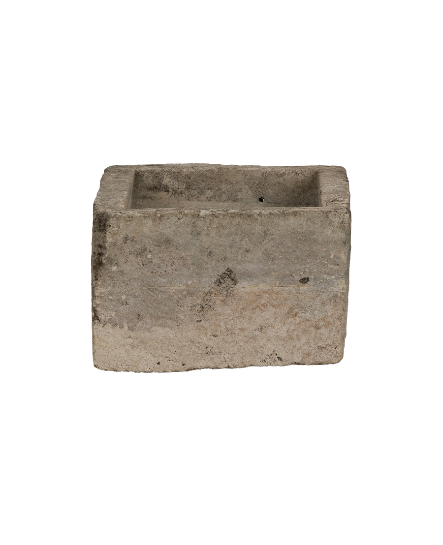 Vintage Indonesian limestone trough, top view with drainage hole visible, ancient character.