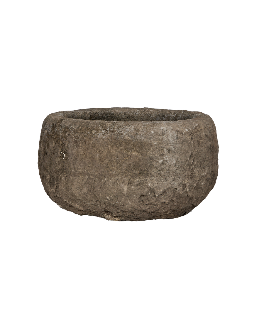 Vintage Indonesian round limestone trough, showing a slightly angled profile and textured surface.