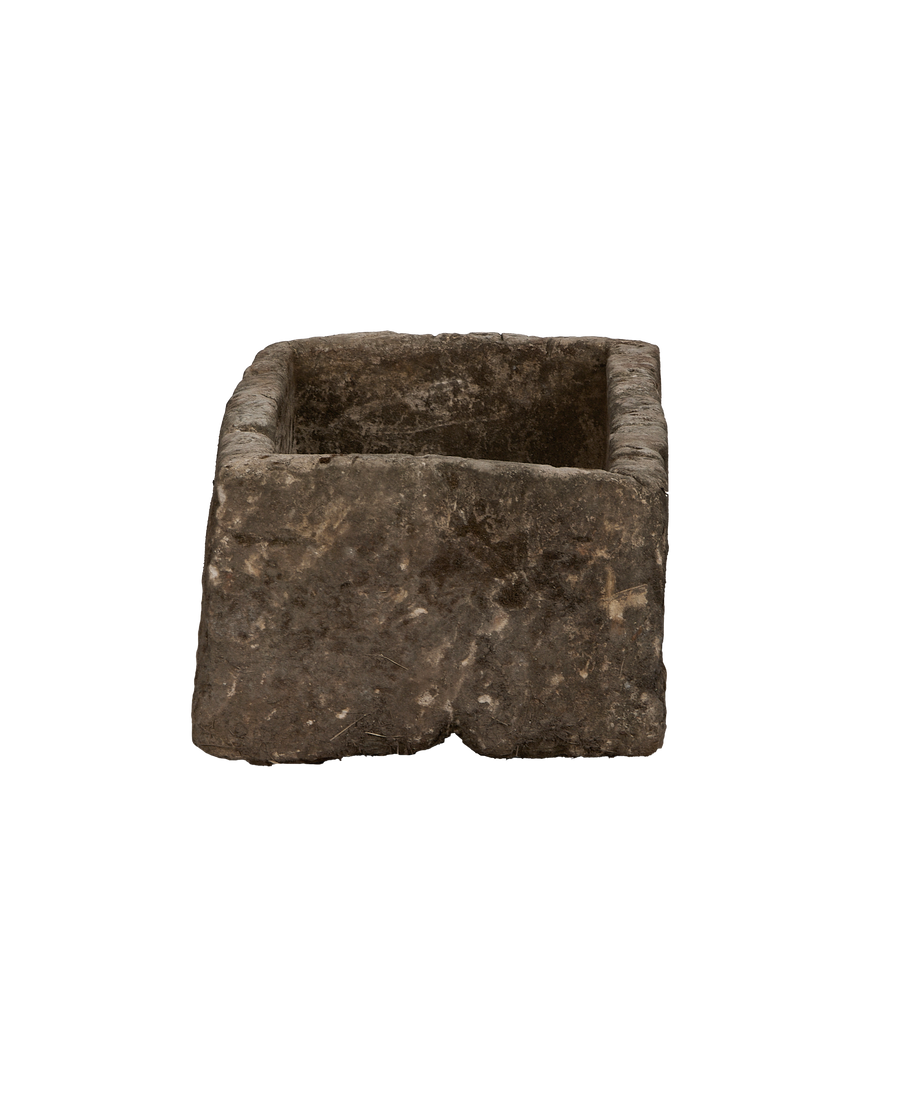 Vintage Indonesian limestone trough viewed from 3/4 angle, showing its rough, weathered texture.