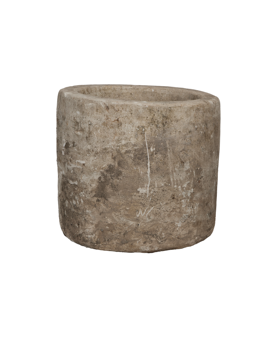 Vintage Indonesian limestone trough, round, showing worn, textured exterior from slightly elevated angle.