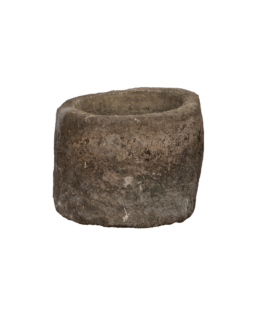 Vintage Indonesian oblong limestone trough, dark patina, showing rough exterior texture and thick wall.