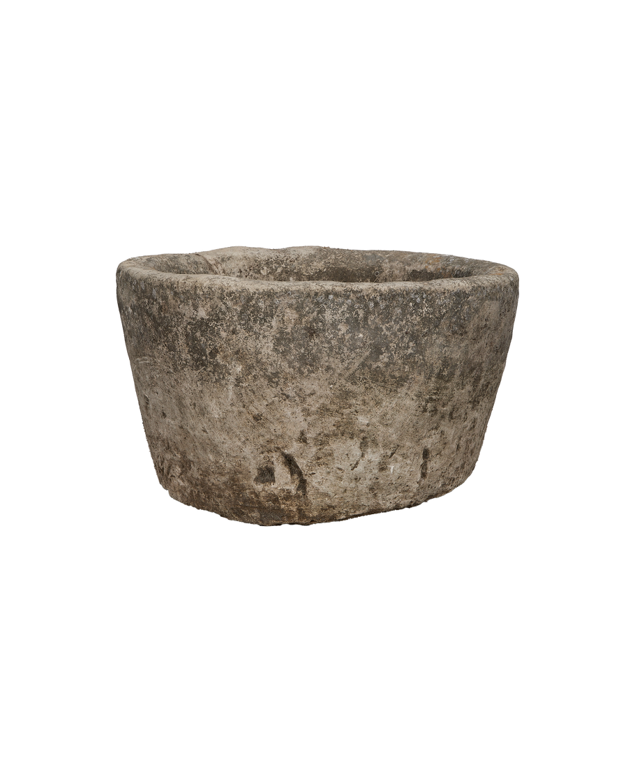 Round vintage Indonesian limestone trough, showing rough exterior texture and irregular rim details.