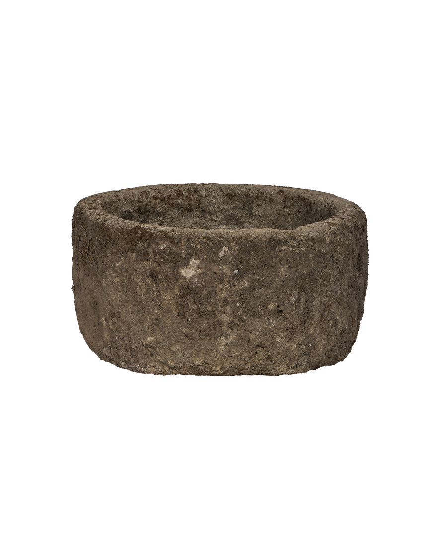 Vintage round limestone trough, showing rough weathered Indonesian texture and uneven rim detail.