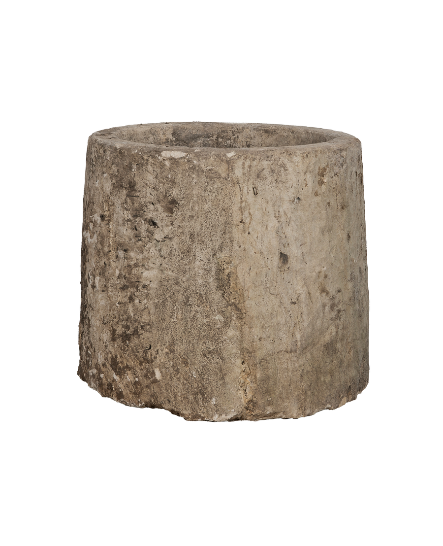 Close-up showing the rustic texture and weathered surface of the vintage limestone trough.