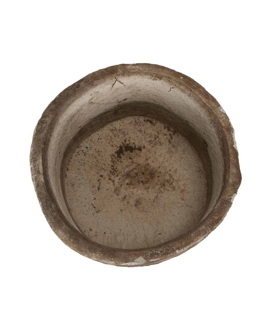 Vintage Indonesian round limestone trough, top view revealing weathered interior texture and cracks.