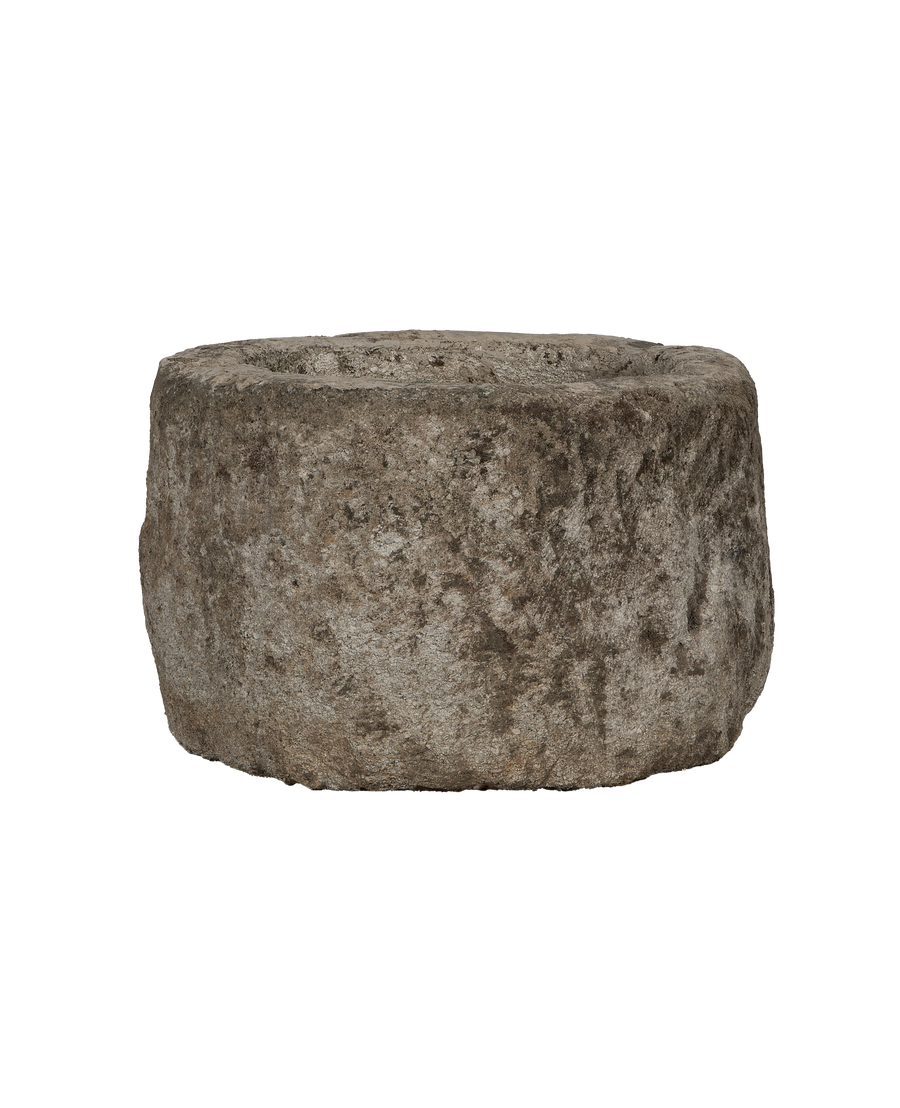 Vintage Indonesian round limestone trough, rough texture, side view.