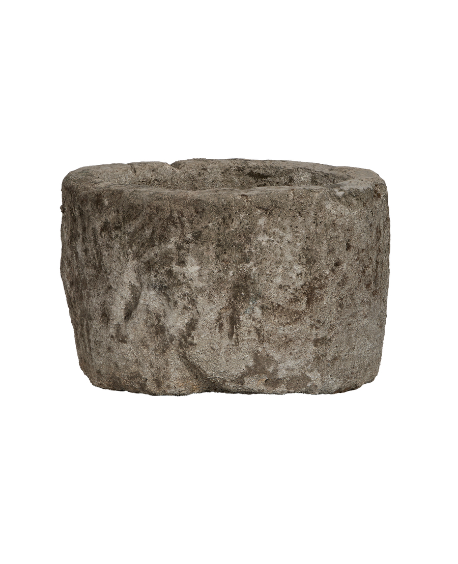 Vintage round limestone trough, rough texture with aged patina, from above.