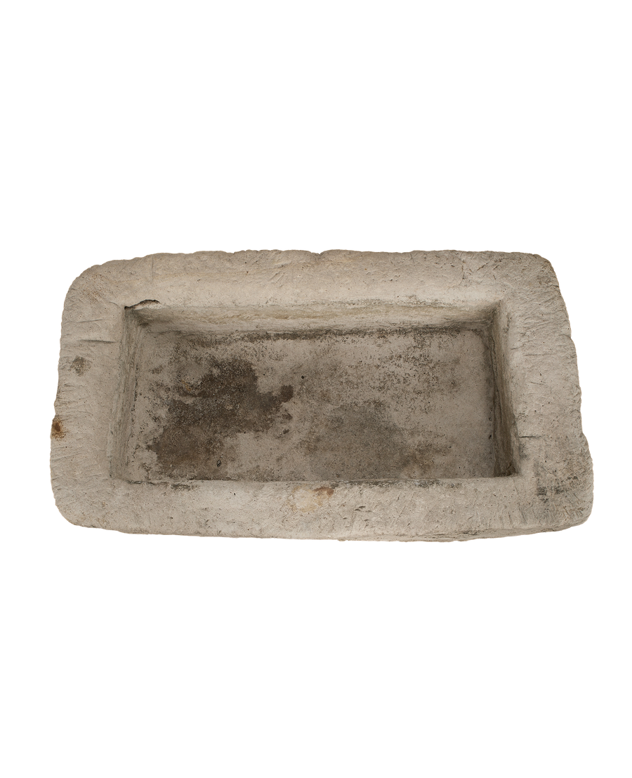 Vintage Indonesian limestone trough closeup, showcasing rough textured edges, weathered patina, and rectangular interior.