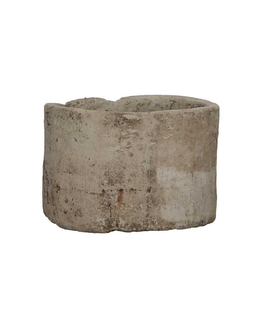 Vintage Indonesian limestone trough, round antique planter, showing rugged exterior with weathered texture.