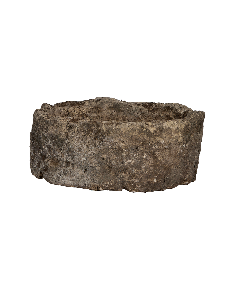 Vintage Indonesian round limestone trough, close-up of textured outer surface.