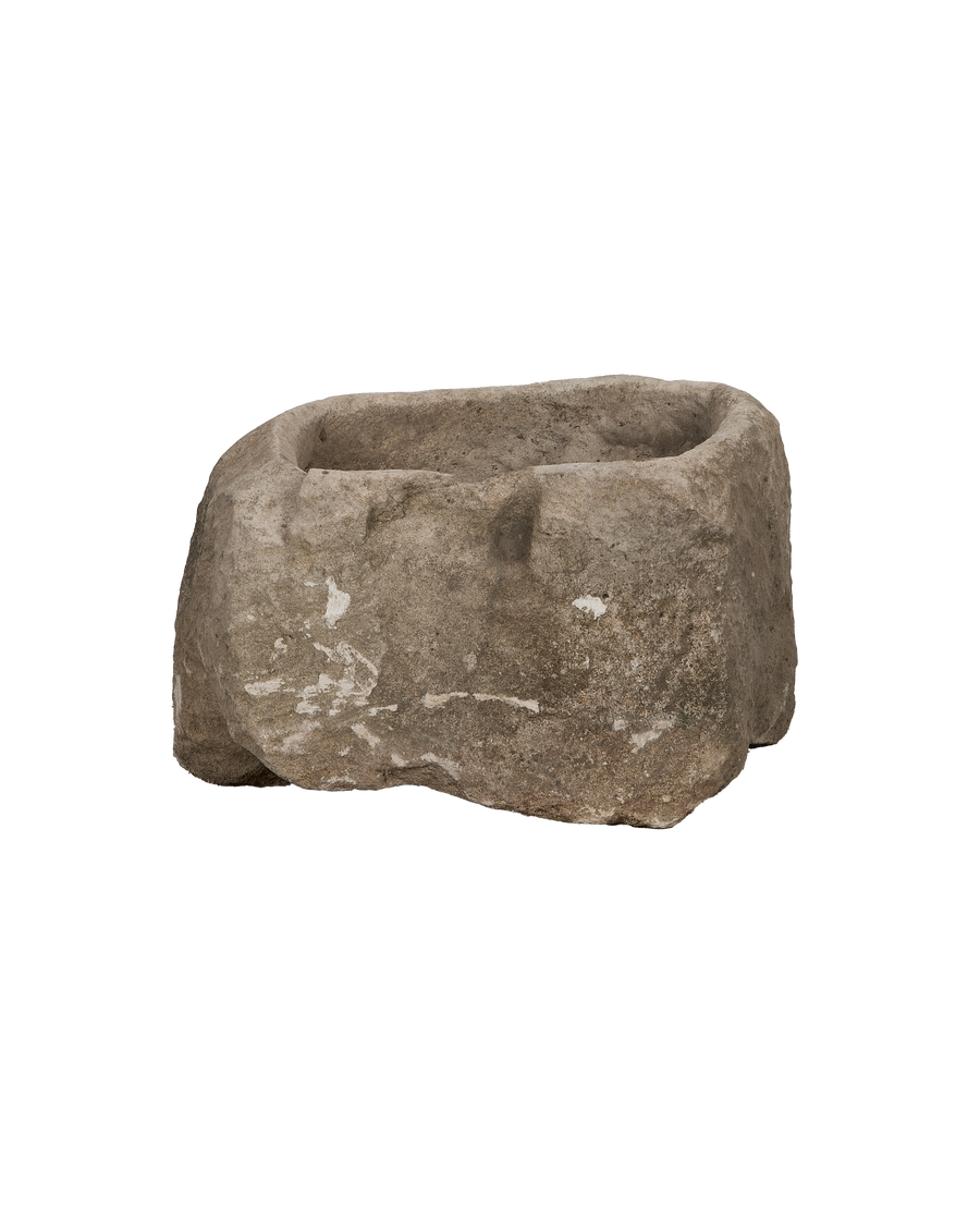 Vintage Indonesian oblong limestone trough, showing its rough texture and weathered details from a side angle.