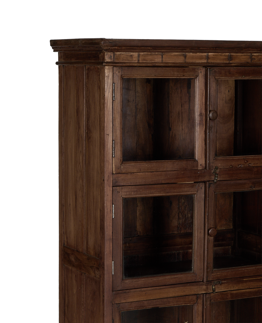 Vintage Indian natural oak cabinet, detail of glass doors, knob, and aged wood grain.