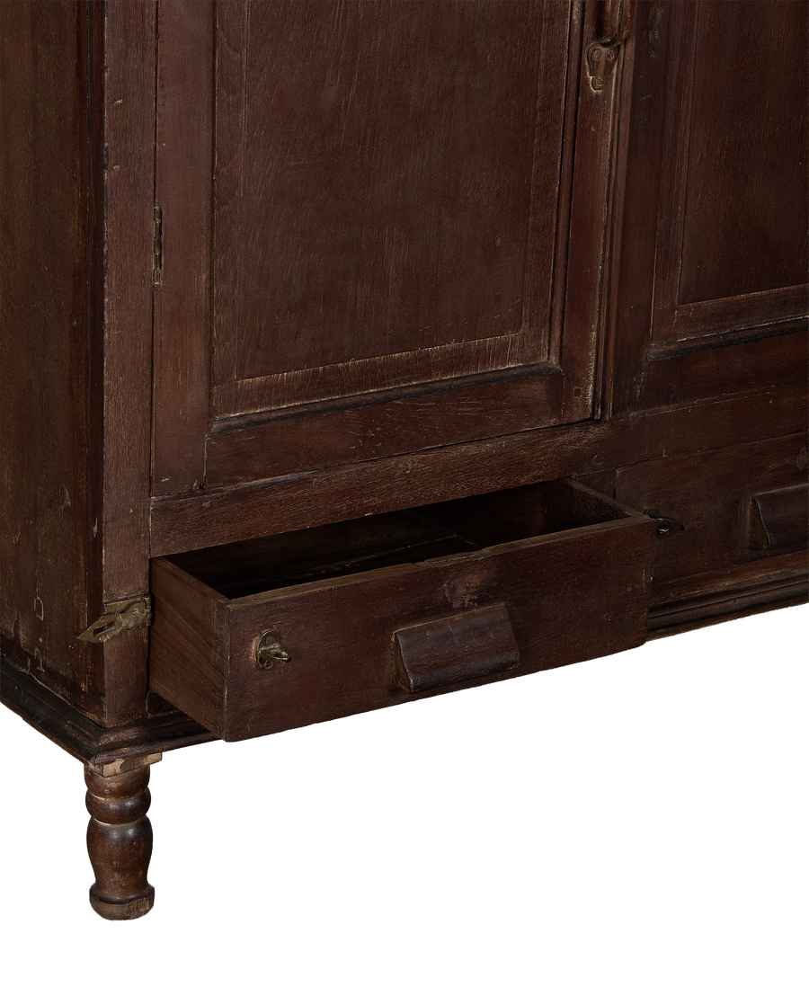 Vintage Indian oak cabinet, stained dark brown, with bottom drawer pulled open, revealing aged interior.