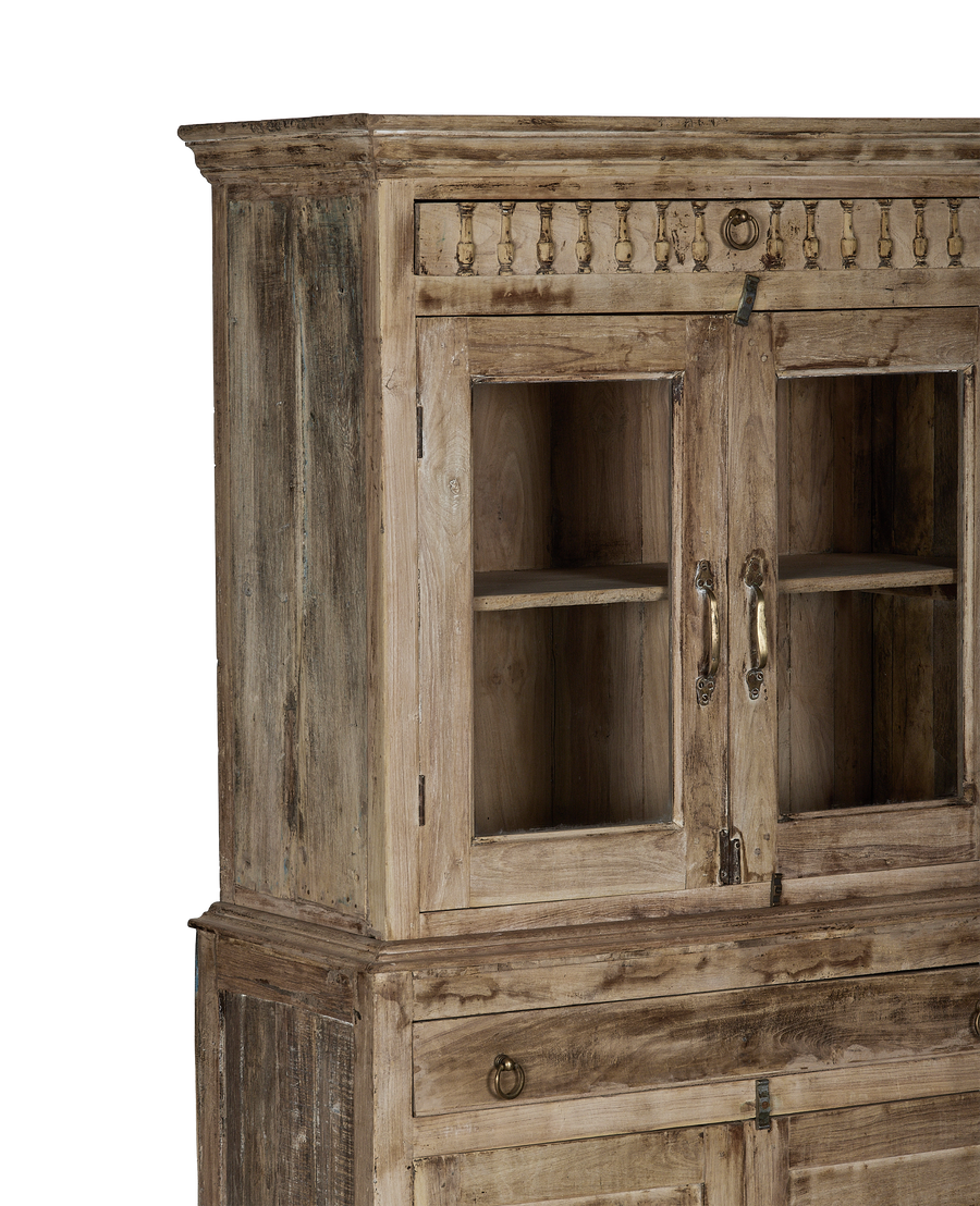 Vintage bleached oak cabinet from India, showing ornate carving and glass doors with brass handles.