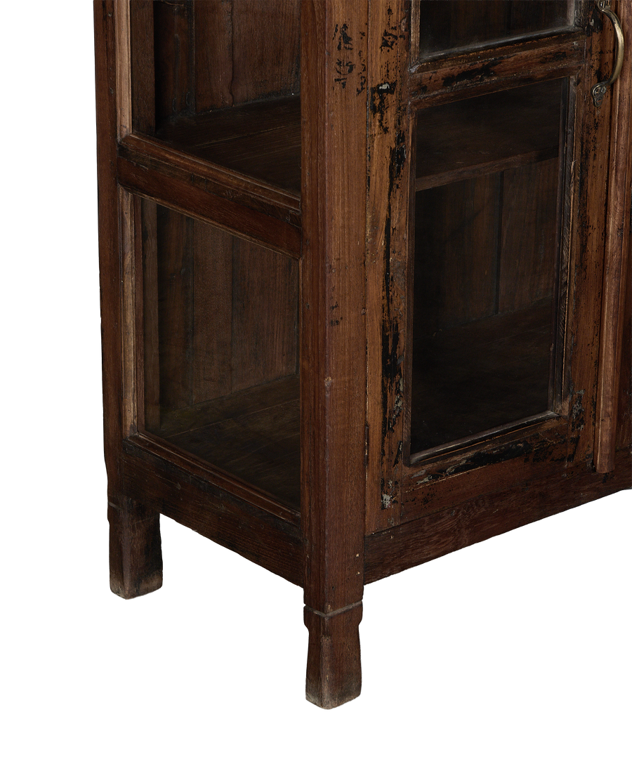 Vintage oak cabinet detail: worn wood frame, glass panels, bottom shelf, and single square leg.