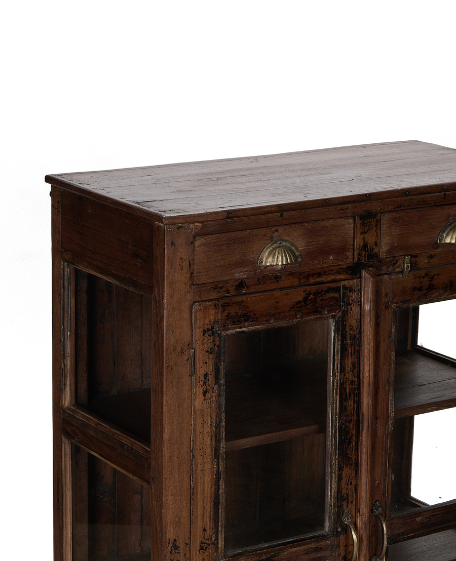 Close-up showing the vintage Indian oak cabinet's natural wood top and brass shell pulls.